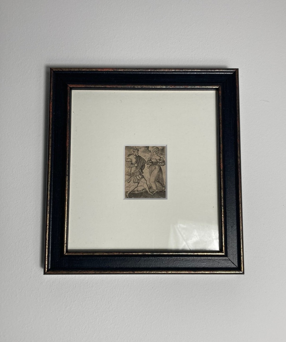 Framed engraving on a white wall
