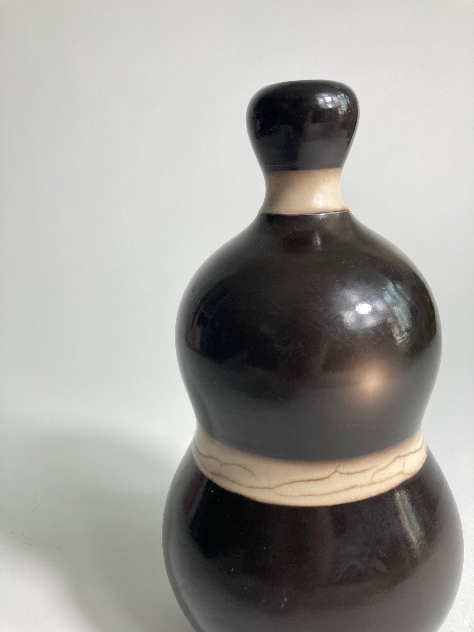 A close up of Raku fired Vase by contemporary ceramic artist John Nuttgens