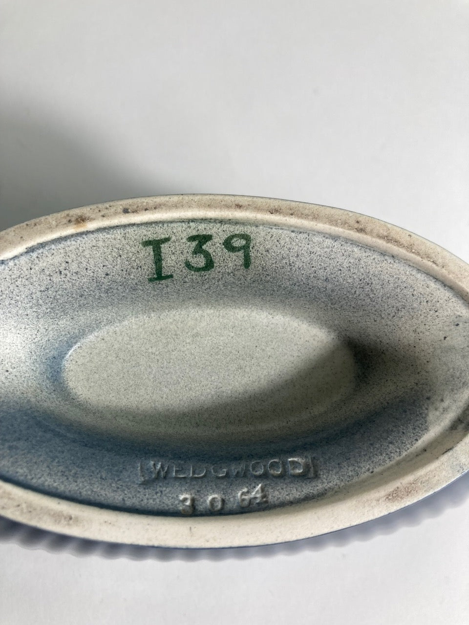 A navy planter produced by Wedgewood and designed by Keith Murray. Makes mark.
